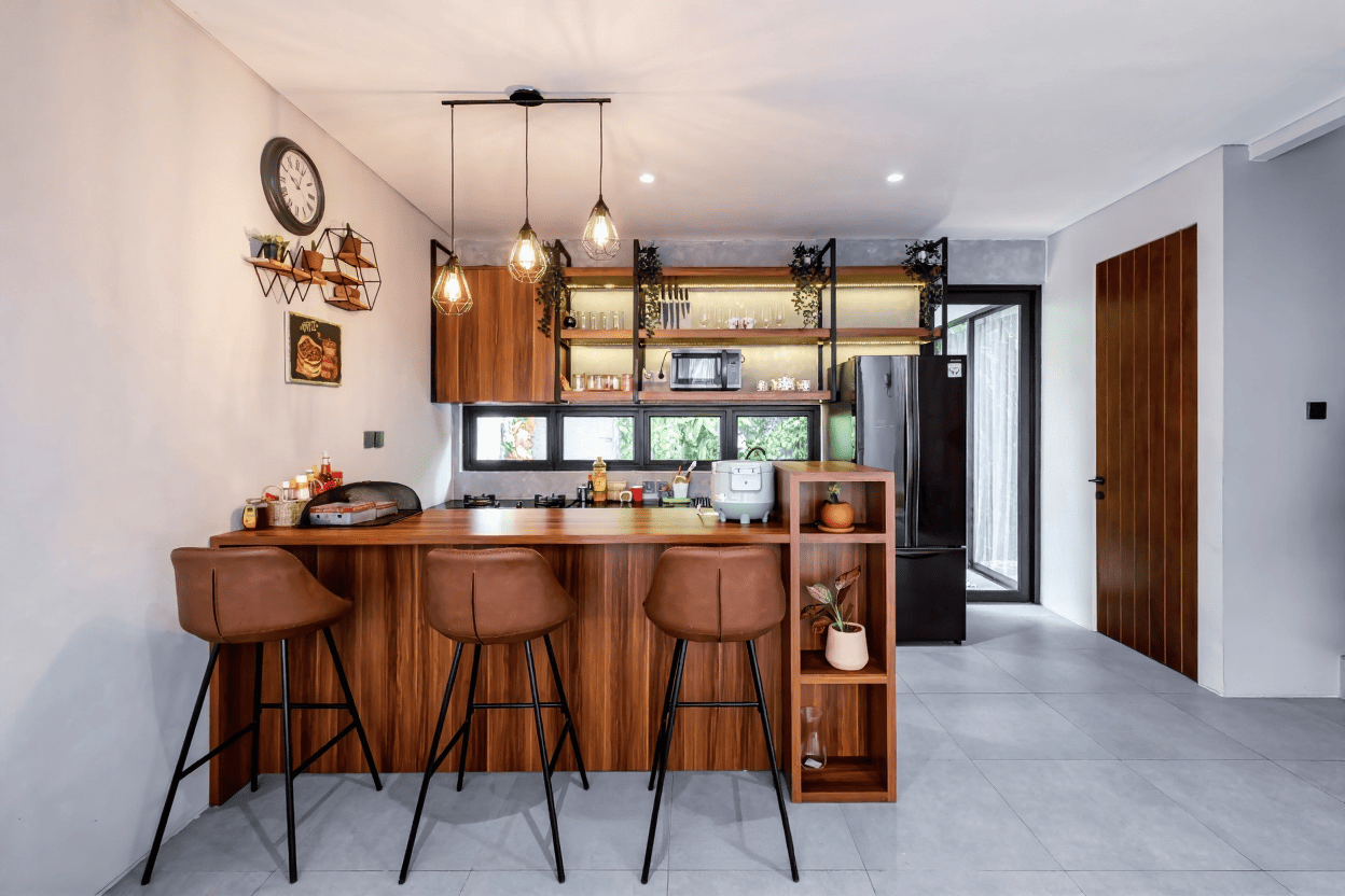 Desain interior dapur bersih modern minimalis dengan meja bar kayu dan lampu gantung estetik karya Laksakusuma Architect